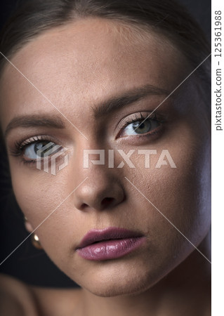 portrait of a young beautiful woman on a dark background portrait of a young beautiful woman on a dark background 125361988