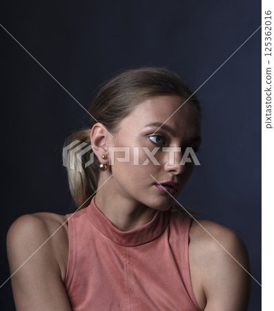 portrait of a young beautiful woman on a dark background portrait of a young beautiful woman on a dark background 125362016
