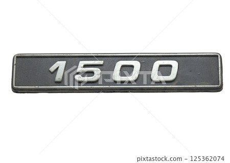 old car emblem. vintage plastic plate, showing engine displacement volume information in cubic centimeters. isolated on white background 125362074