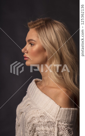 Studio photo portrait of a young pretty blonde on a dark background, close-up portrait of a woman 125362136
