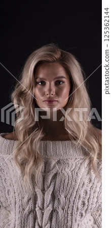 Studio photo portrait of a young pretty blonde on a dark background, close-up portrait of a woman 125362144