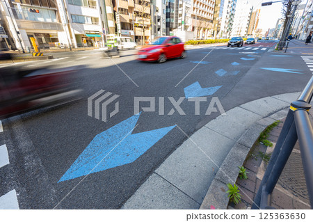 帶有箭頭羽毛狀道路標記的道路：藍色箭頭警告自行車通行 125363630