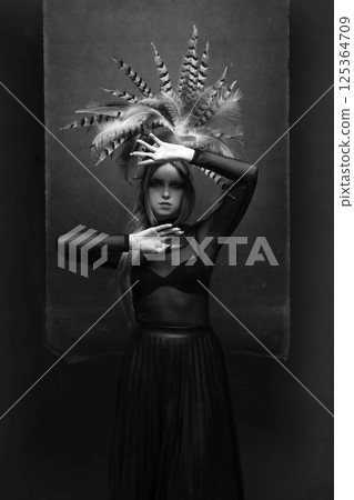 Woman with feather headpiece studio portrait Woman with feather headpiece studio portrait 125364709