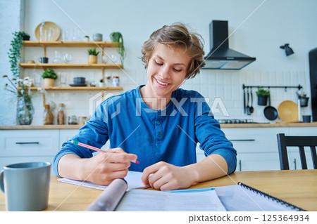 Webcam portrait male student teenager, sitting at home at the table Webcam portrait male student teenager, sitting at home at the table 125364934