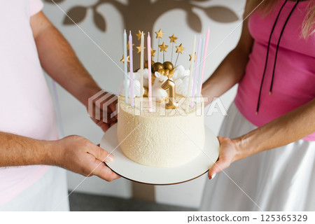 Parents Holding A First Birthday Cake 125365329