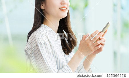 Smiling woman/businesswoman using a smartphone 125366258