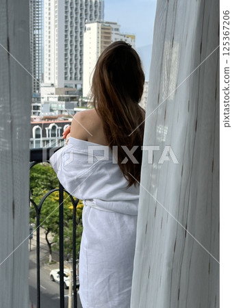 A elegant luxury woman with a white enjoys the view over the Downtown City A elegant luxury woman with a white enjoys the view over the Downtown City 125367206