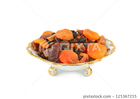 A selection of dried fruits in a vintage porcelain fruit bowl isolated on white. 125367255