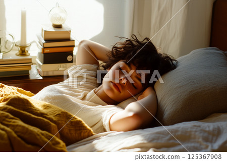 A woman is sleeping on a bed with a yellow blanket A woman is sleeping on a bed with a yellow blanket 125367908
