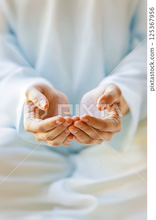 A person is holding their hands outstretched, as if to receive something 125367956