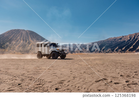 Off road vehicle parked by the Volcanic Mount Bromo on desert wilderness at Indonesia Off road vehicle parked by the Volcanic Mount Bromo on desert wilderness at Indonesia 125368198