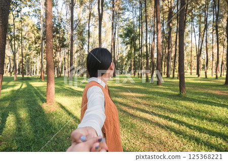 Woman holding hands in pine forest during the evening Woman holding hands in pine forest during the evening 125368221