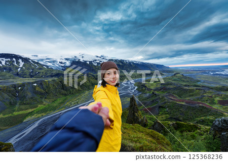 Asian woman enjoying surrounded by lush rugged volcanic mountain at Valanukur, Thorsmork, Iceland 125368236