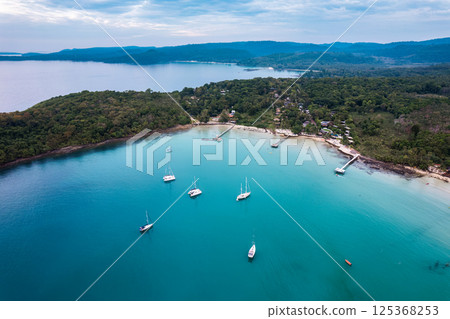 Beautiful Koh Kood Island with boat and yacht and wooden pier in tropical sea Beautiful Koh Kood Island with boat and yacht and wooden pier in tropical sea 125368253