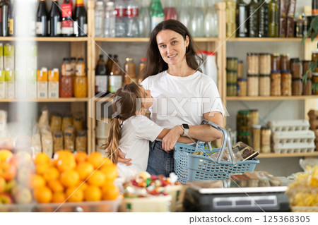 Happy child snuggles up to mother at grocery 125368305