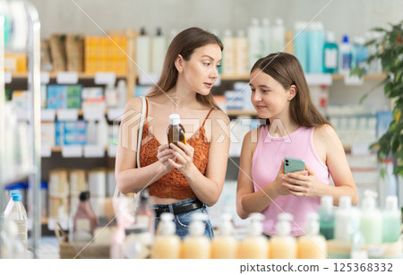 woman with a child chooses cough syrup 125368332