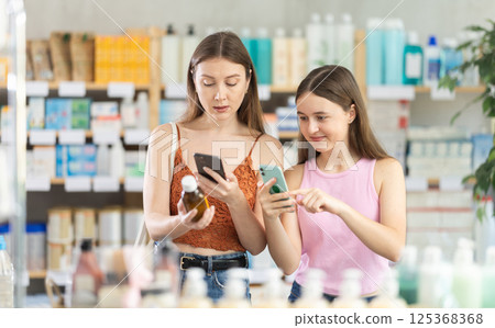 Woman with daughter scanning qr code of syrup 125368368