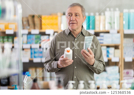 Older man choosing skincare products in pharmacy 125368536