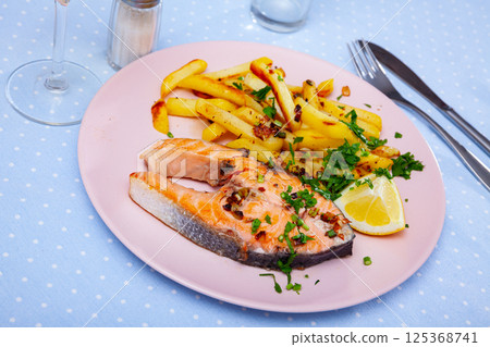 Tasty grilled salmon served with french fries 125368741