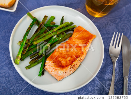 Roasted salmon steak and green asparagus on plate 125368763