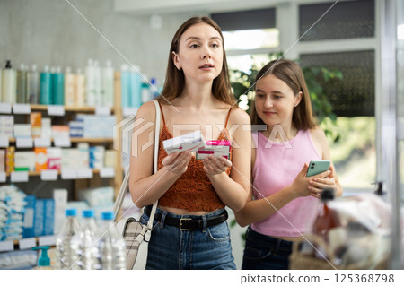 Mom and teen girl child buyer select paracetamol tablet medicine 125368798