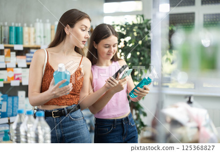 Woman and daughter scan mouthwash barcode on phone 125368827