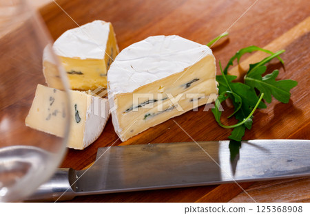 Slices of soft blue cheese on cutting board Slices of soft blue cheese on cutting board 125368908