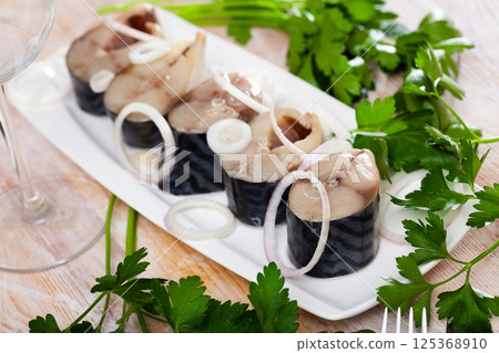 Lightly salted mackerel cut into pieces with parsley and onion on table Lightly salted mackerel cut into pieces with parsley and onion on table 125368910