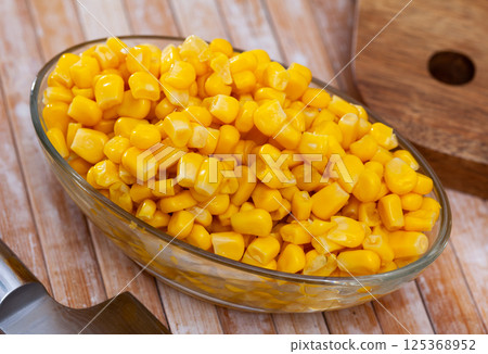 Sweet canned corn in bowl on table 125368952