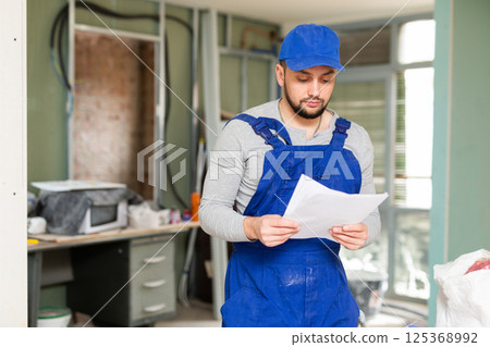 Foreman reading papers on indoor construction site Foreman reading papers on indoor construction site 125368992