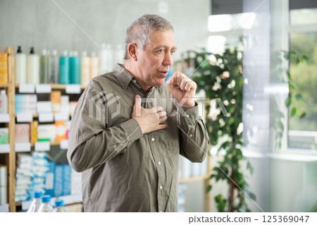 Senior man visits pharmacy and suffers from cough 125369047