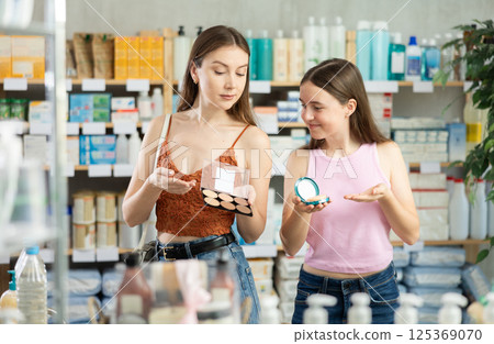 Daughter and mothers choose cosmetics in the pharmacy 125369070