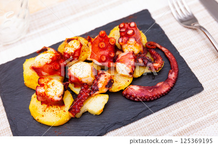 Pulpo a la gallega on serving board 125369195