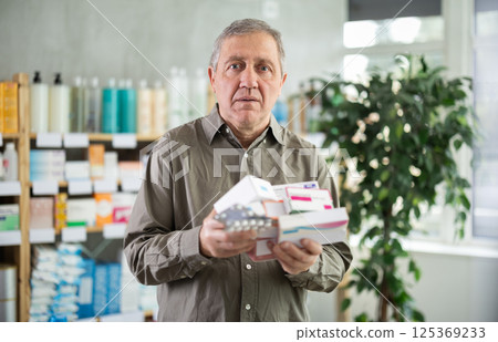 Senior man choosing from many medications at pharmacy Senior man choosing from many medications at pharmacy 125369233
