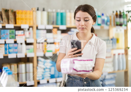 Young woman scanning pads on mobile 125369234