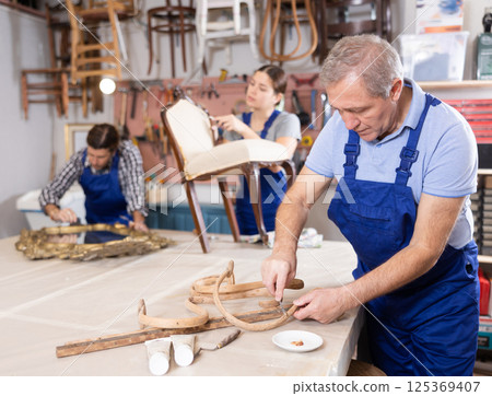 Experienced craftsman cleaning plaque and dirt from wooden vintage parts Experienced craftsman cleaning plaque and dirt from wooden vintage parts 125369407