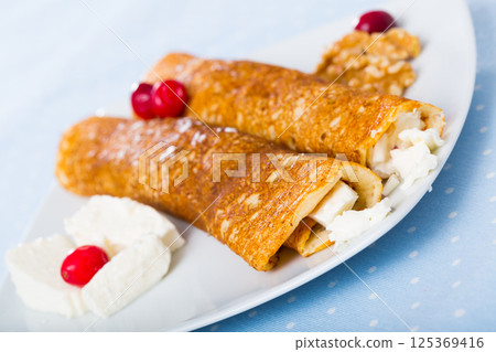 Dish of pancakes palachinki with filling from brynza and walnuts Dish of pancakes palachinki with filling from brynza and walnuts 125369416
