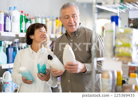 Couple man and woman choosing shampoo or shower gel in store Couple man and woman choosing shampoo or shower gel in store 125369435