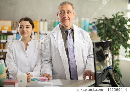 Portrait of two positive pharmacists in modern drugstore Portrait of two positive pharmacists in modern drugstore 125369444
