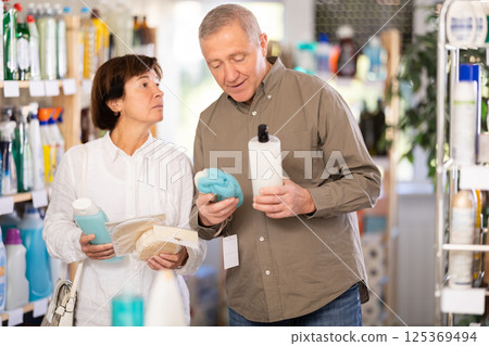 Couple man and woman choosing shampoo or shower gel and washcloth 125369494