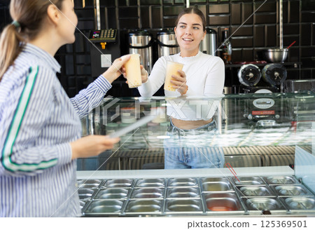 Young woman works as bartender and sells bubble tea Young woman works as bartender and sells bubble tea 125369501