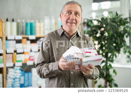 Senior man choosing from many medications at pharmacy 125369520