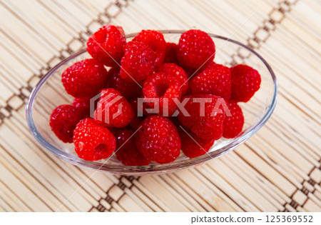 Fresh and tasty looking raspberries on table Fresh and tasty looking raspberries on table 125369552