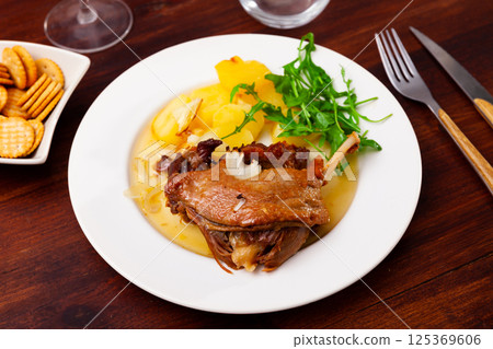 French dish duck confit with arugula on table French dish duck confit with arugula on table 125369606