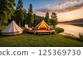 Tranquil lakeside glamping at sunset with cozy campfire and scenic nature views 125369730