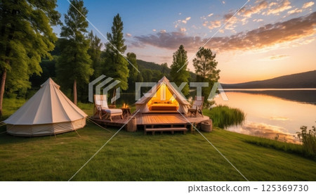 Tranquil lakeside glamping at sunset with cozy campfire and scenic nature views 125369730