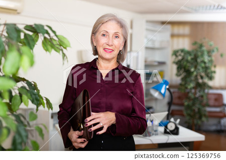Businesswoman with briefcase for documents in office 125369756