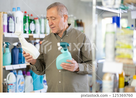 European man choosing spray in supermarket European man choosing spray in supermarket 125369760