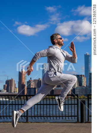 Morning sport workout runner running. Sport runner in Manhattan. Sportsman in New York. Man sportsman running for exercise in active wear. Sportsman jogger running. Sport lifestyle Morning sport workout runner running. Sport runner in Manhattan. Sportsman in New York. Man sportsman running for exercise in active wear. Sportsman jogger running. Sport lifestyle 125369788