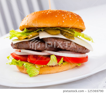 Tasty double-decker grilled burger with beef, tomato, cheese Tasty double-decker grilled burger with beef, tomato, cheese 125369790